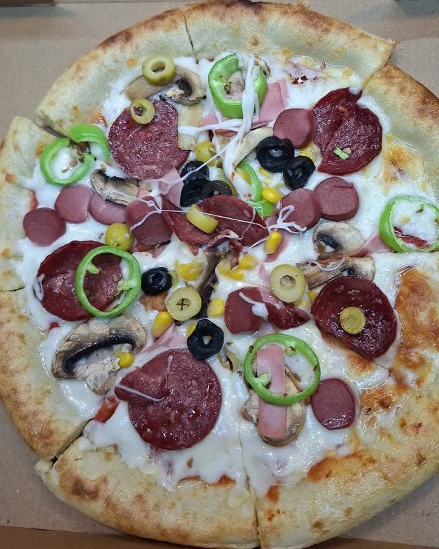 Kutusunda dilimlenmiş karışık pizza.